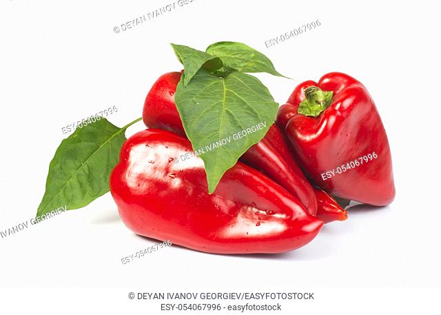 Red peppers and leaves. White isolated studio shot