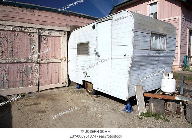 White beatup trailer parked in front of pink garage, Ventura, California, USA