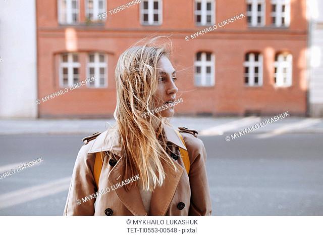 Young woman by brick building