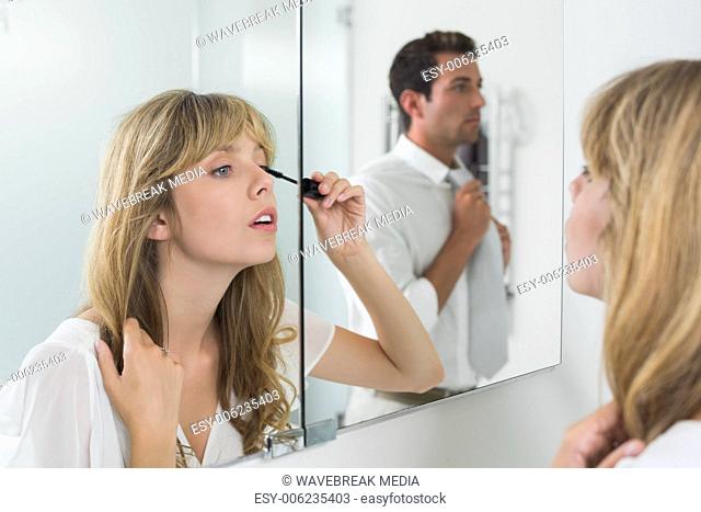 Close-up of a beautiful young woman applying mascara