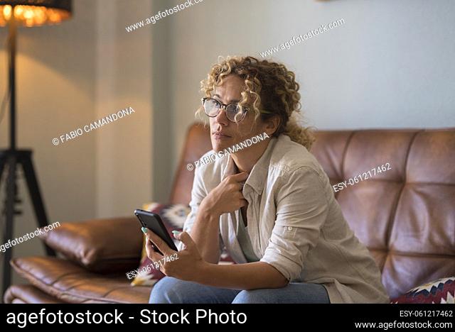Close up of woman using modern smart phone at home sitting on the sofa enjoying internet connection wireless - female people with application on cellular...