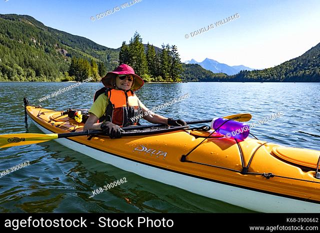 A woman kayaks on Hicks Lake, British Columbia, Canada