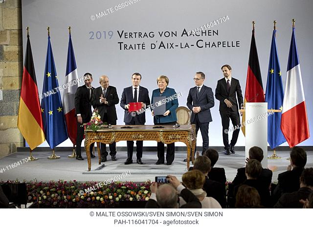 Emmanuel MACRON, President of the French Republic, and with Chancellor Angela MERKEL sign the treaty, French Foreign Minister Jean-Yves Le Drian on the left and...