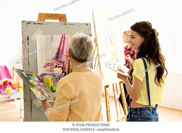 happy women painting at art school studio