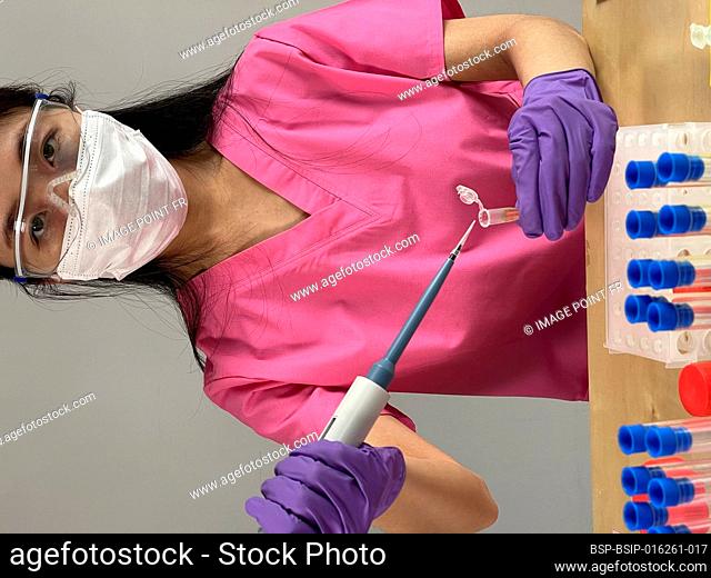 Woman injecting a substance into a tube using a pipette