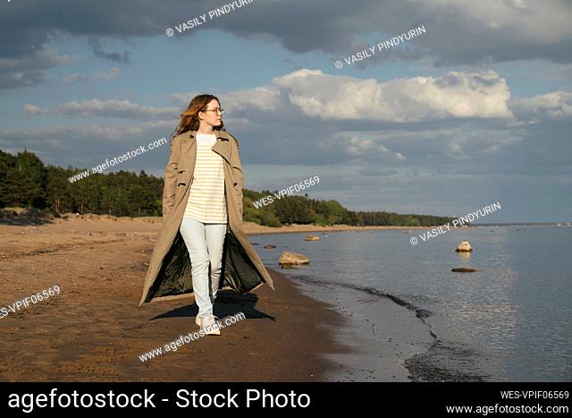 Young woman walking by sea at beach