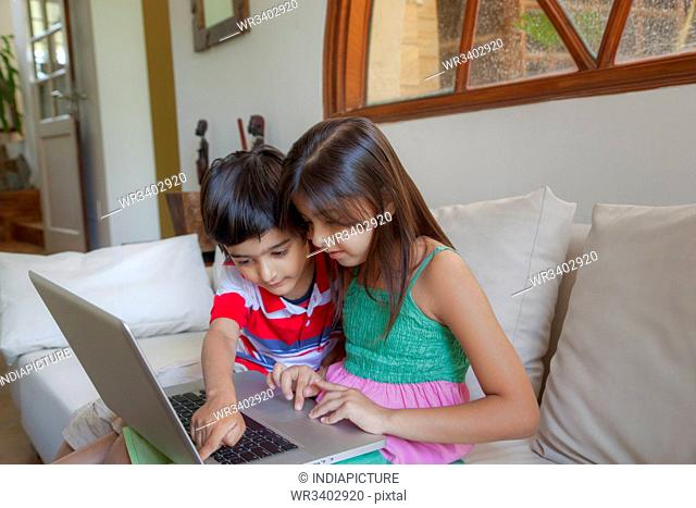 Brother and sister working on a laptop