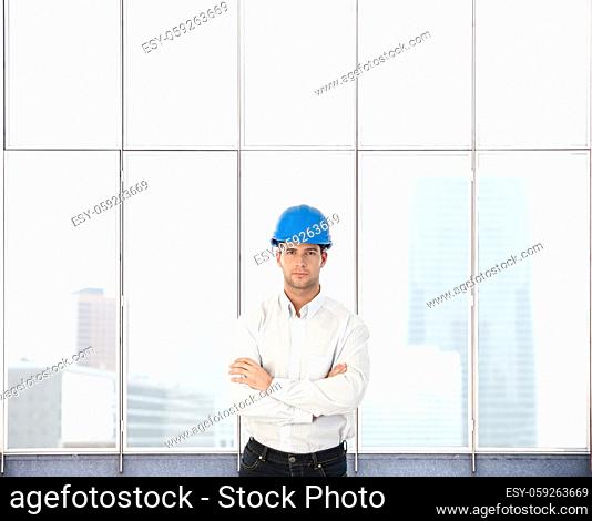 Portrait of architect designer man standing at skyscraper window. Copyspace