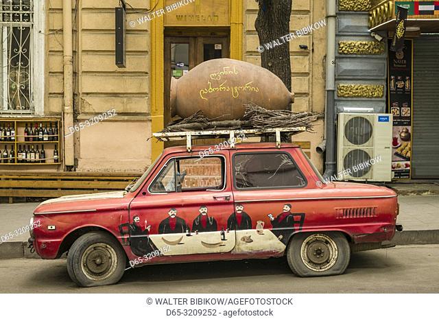 Georgia, Tbilisi, Old Town, Zaporozhets car with wine barrel advertising wine bar