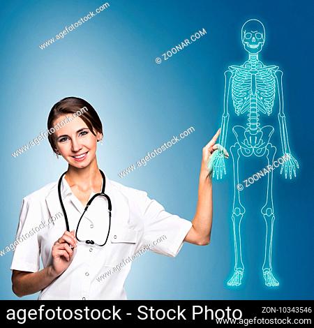 Medical doctor woman pointing on drawing human skeleton, over blue background