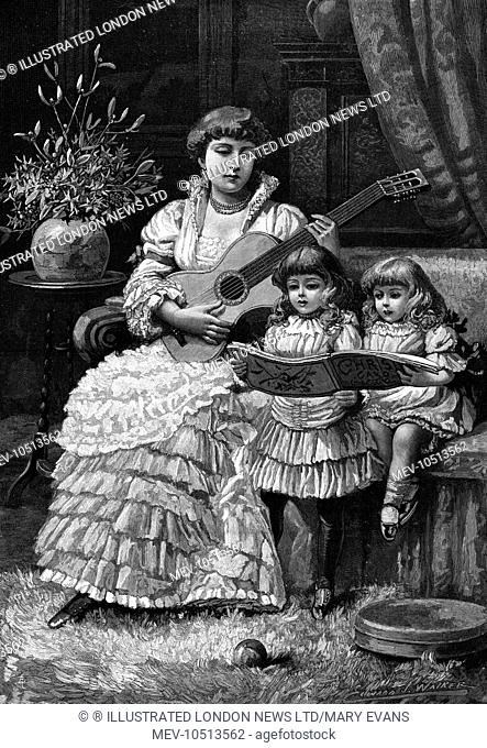 A woman seated on a couch plays the guitar whilst two little girls sing Christmas carols from a music book. Some holly and mistletoe in a vase complete the...