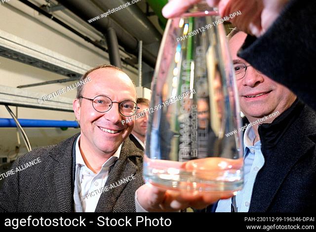 12 January 2023, Saxony, Torgau: Wolfram Günther (Greens), Saxony's Minister of Agriculture, looks at a water sample at the Torgau East waterworks