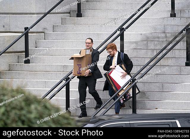 People carrying paraphernalia depart the Eisenhower Executive Office Building in the waning days of the Trump Administration in Washington, DC on Friday