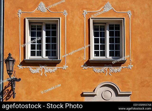 Windows with decorations and lanter on the wall of renovated old tenement house in Gdansk Old Town, Poland
