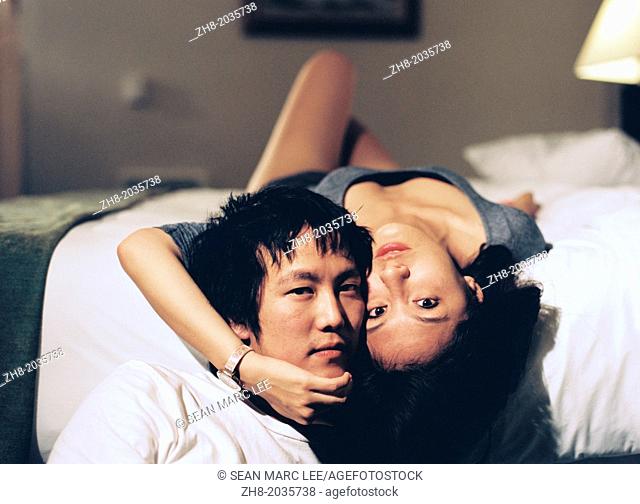 An young couple embracing each other on a bed