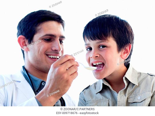 Assertive doctor giving medicine to a little boy