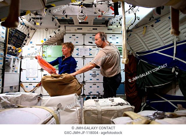 Rob Tomaro, crew systems instructor, works with NASA astronaut Sandy Magnus, STS-135 mission specialist, on the middeck of the Full-Fuselage Trainer during a...