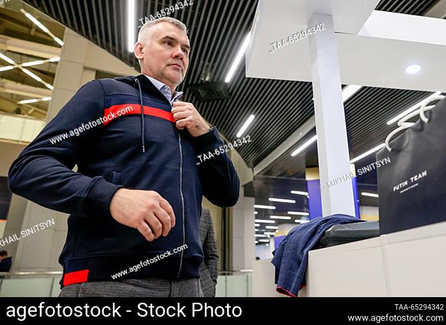 RUSSIA, MOSCOW - NOVEMBER 28, 2023: A man tries on a zip hooded sweatshirt in a newly-opened Putin Team Russia clothing store at the Russia Expo international...
