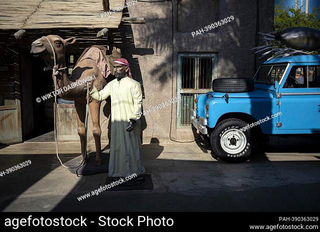 A figure of a man dressed in a thawb leading a camel at a tourist office in the old city of Dubai , United Arab Emirates on 31/12/2022 by Wiktor Dabkowski