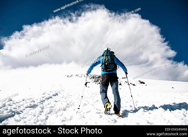 Mountaineer rises uphill to meet a mountain storm coming from the mountain on caucasus
