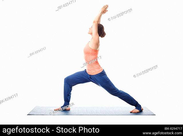 Beautiful sporty fit yogini woman practices yoga asana Virabhadrasana 1, warrior pose 1 isolated on white