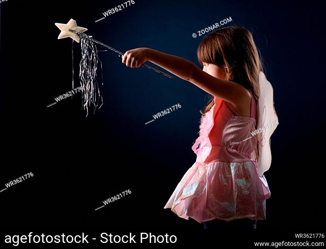 little girl dressed up as a fairy with a magic wand