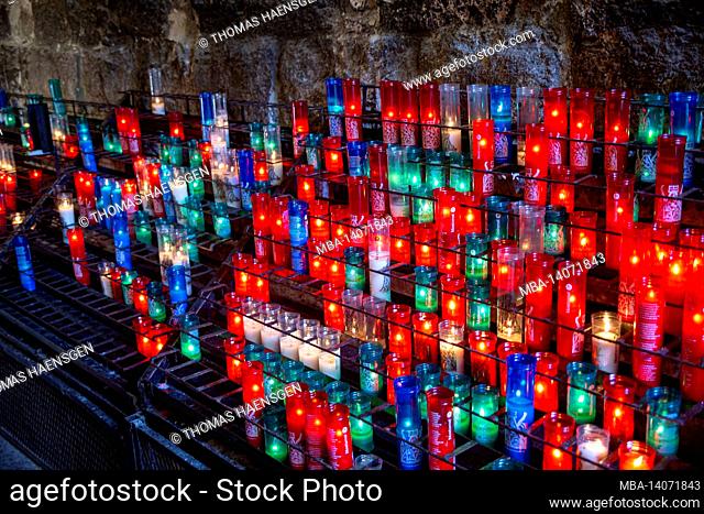 barcelona, spain: candles of different sizes and colors inside the monastery of santa maria de montserrat