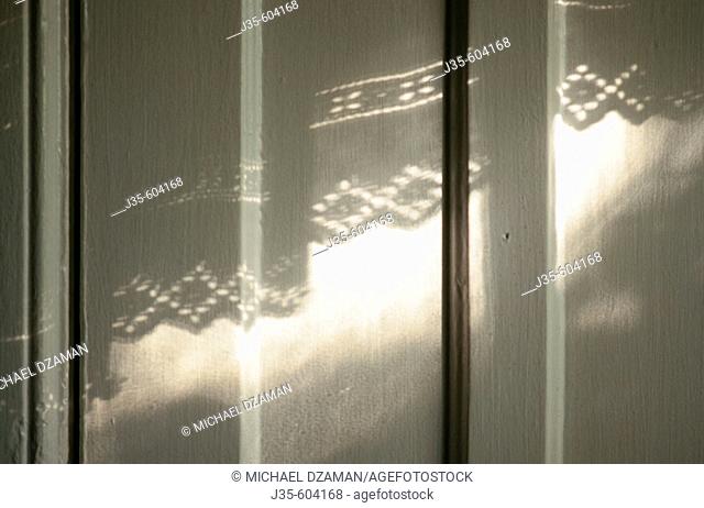 Shadow of curtain on white door