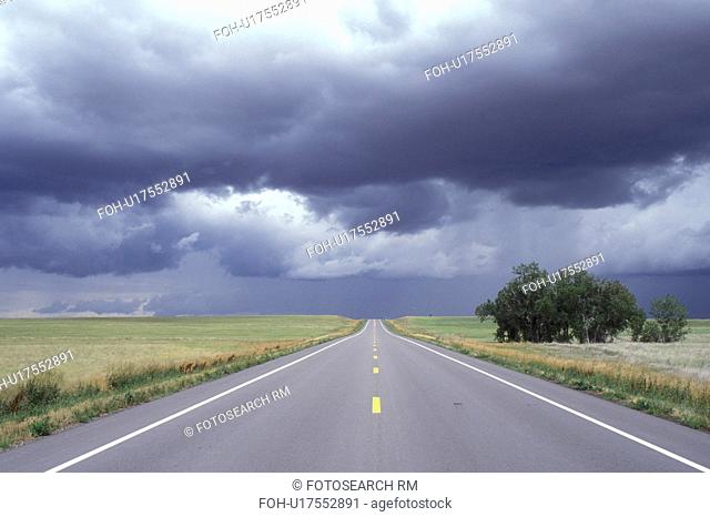 Nebraska, The storm clouds hover overhead as Highway 20 stretches for miles into the distant horizon