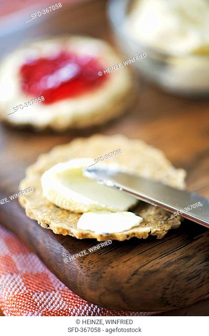 Spreading oatcake with soft cheese