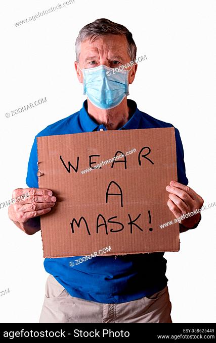 Senior caucasian man holding a blank cardboard sign saying wear a mask. He is isolated against a white background