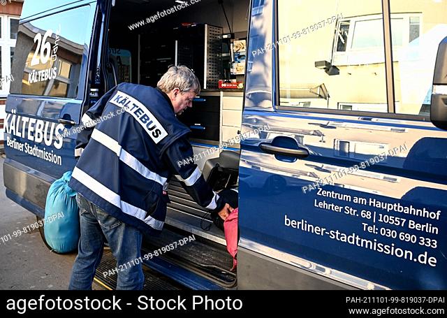 28 October 2021, Berlin: Cold bus driver Matthias Spreemann loads the cold bus with sleeping bags and prepares the vehicle for use