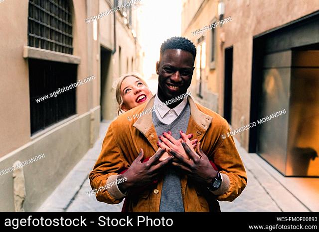 Portrait of happy young couple in an alley in the city of Florence, Italy