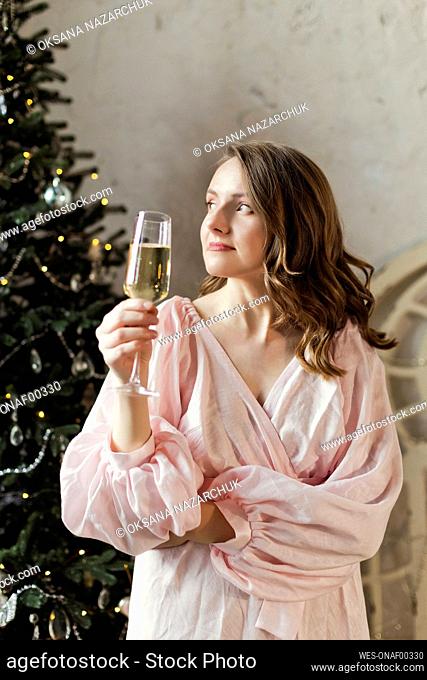Woman holding glass of champagne at home