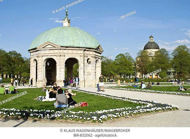 People enjoying the warm spring day in front of the pavilion for the goddess Diana in the Hofgarten, Munich, Bavaria, Germany, Europe