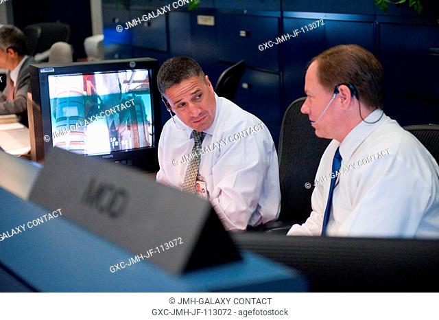 John McCullough (right), chief of the Flight Director Office; and astronaut George Zamka are pictured at the MOD console in the space shuttle flight control...