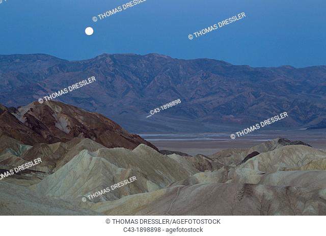 Full moon at dawn over the Panamint Range and the Death Valley  Seen from Zabriskie Point with the badlands of Gower Gulch in the foreground  Death Valley...