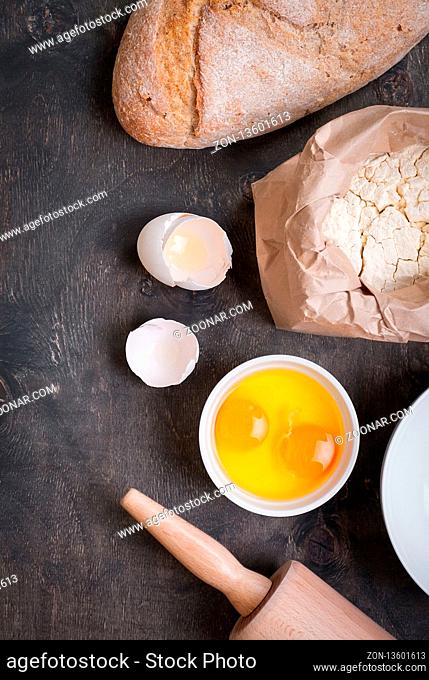 Baking background with eggshell, bread, flour, rolling pin. Close up