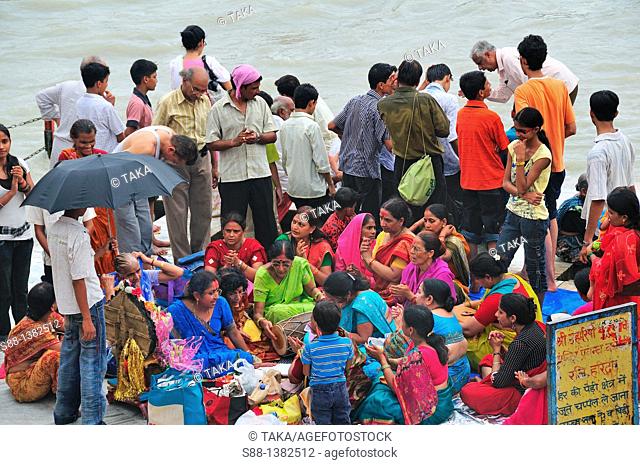 Pilgrim women playing music at Har Ki Pairi ghat by the Ganges river