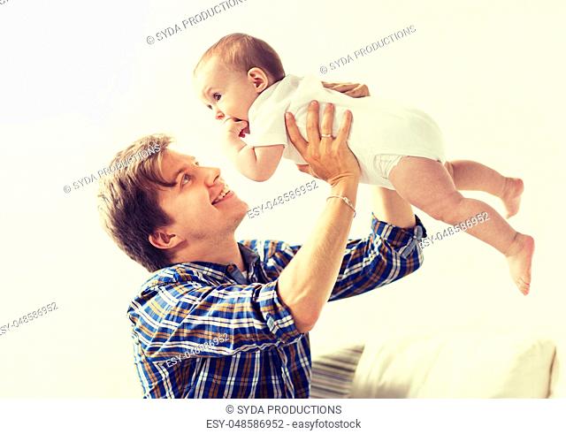 happy young father playing with baby at home