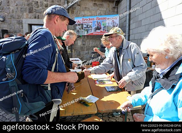 22 May 2022, Saxony-Anhalt, Schierke: Record hiker Benno Schmidt, alias Brocken-Benno, signs books during a ceremony. The record hiker celebrated his 9000th...