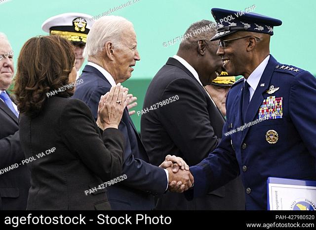 United States Vice President Kamala Harris (left) applauds as US President Biden (center) shakes hands with US Air Force General Charles Q