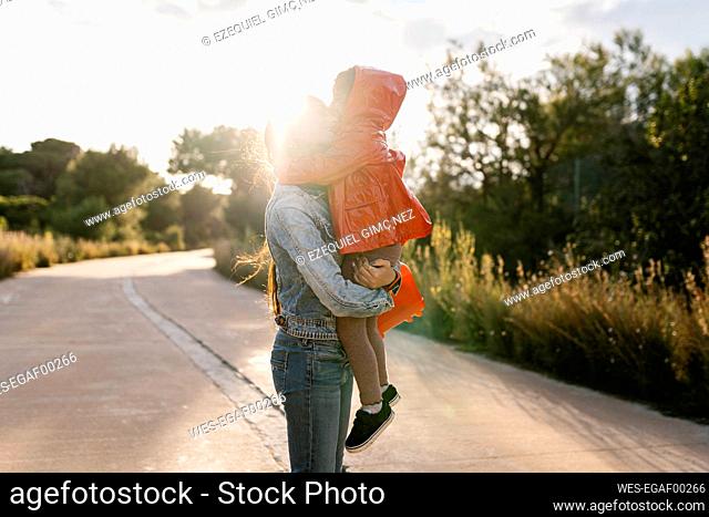 Mother holding her daughter on way outdoors