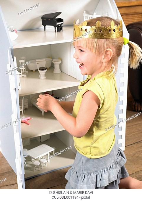 Little girl playing with a doll house