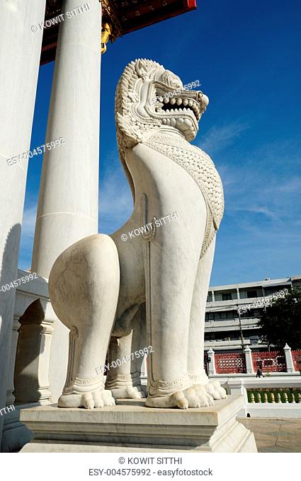 antique guardian lion sculpture in front of the temple, thailand