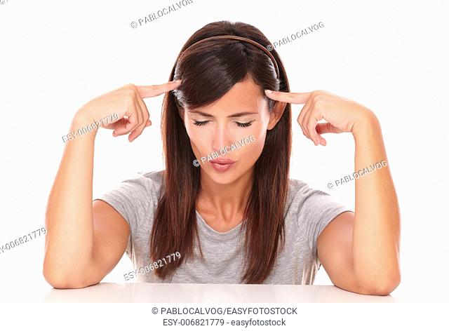 Portrait of pensive woman with her fingers on head and closed eyes wondering on isolated studio