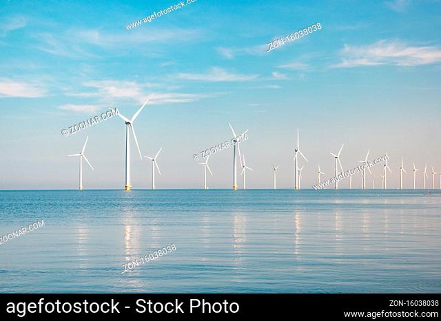 offshore windmill park with stormy clouds and a blue sky, windmill park in the ocean. Netherlands Europe
