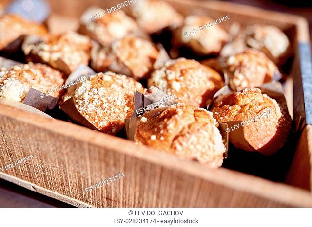 food, culinary, baking, cooking and pastry concept - close up of muffins in wooden box