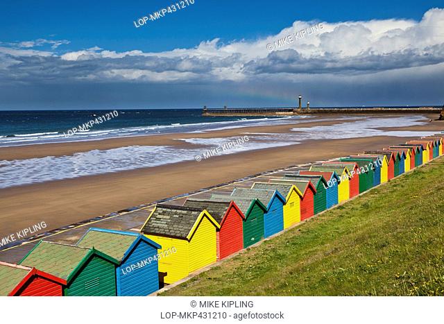 England, North Yorkshire, Whitby. Colourful beach huts along West Cliff Beach in Whitby