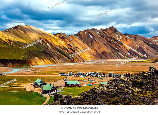 Iceland in July. Great Valley Park Landmannalaugar, surrounded by mountains of rhyolite and unmelted snow. In the valley built large camp